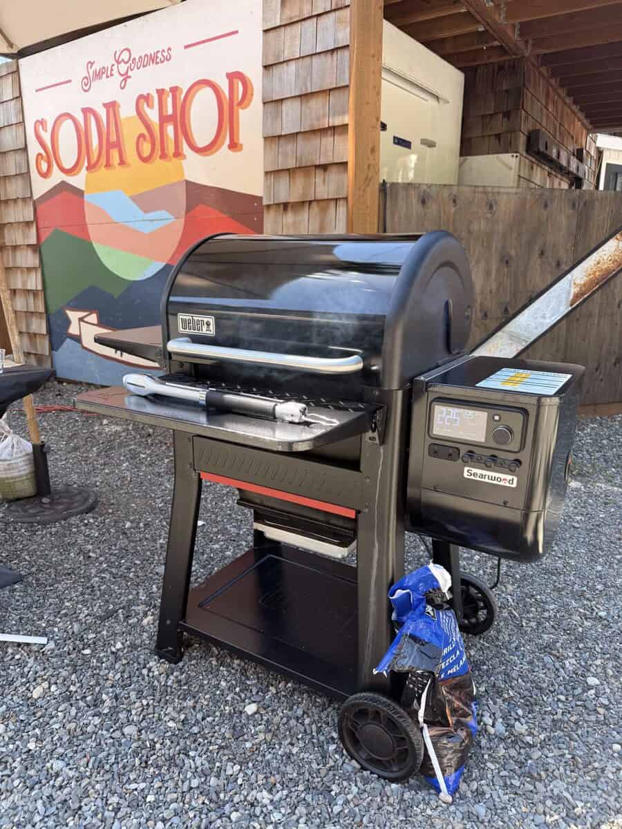 Black outdoor grill with digital controls and cover, ready for cooking.