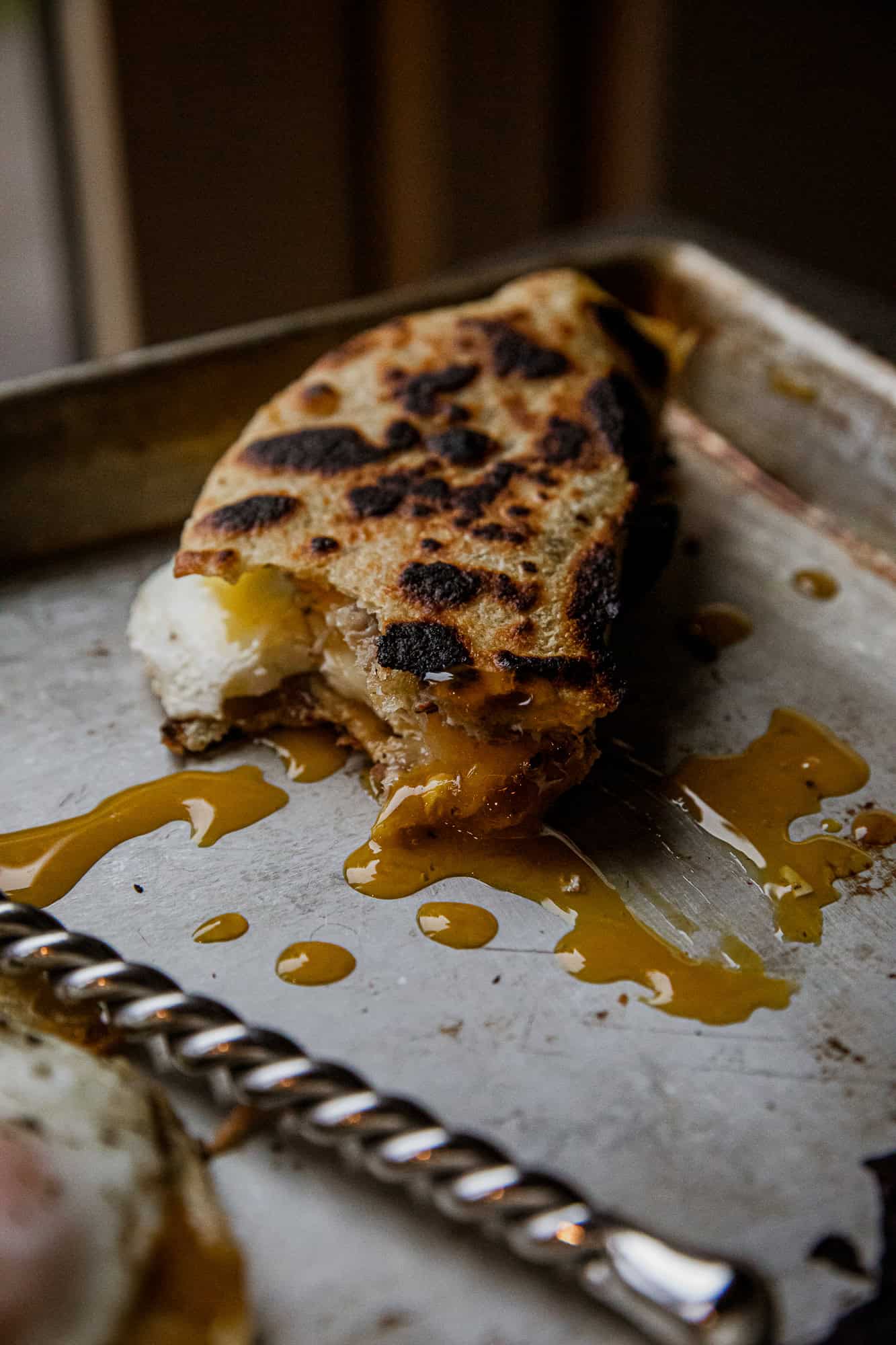Close-up of a breakfast taco with melted cheese and caramelized onions.