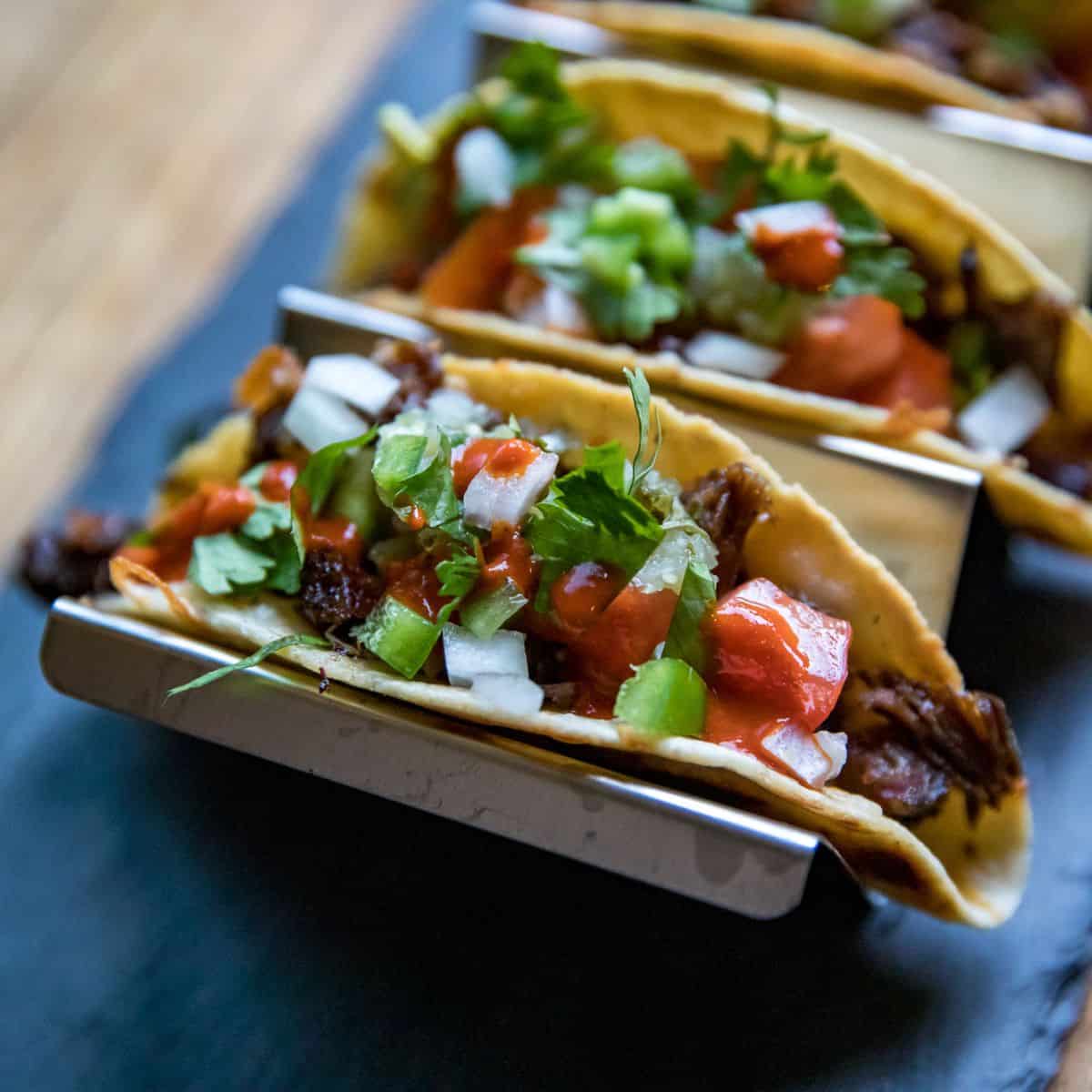 Delicious tacos with beef, vegetables, and fresh toppings for tailgating.