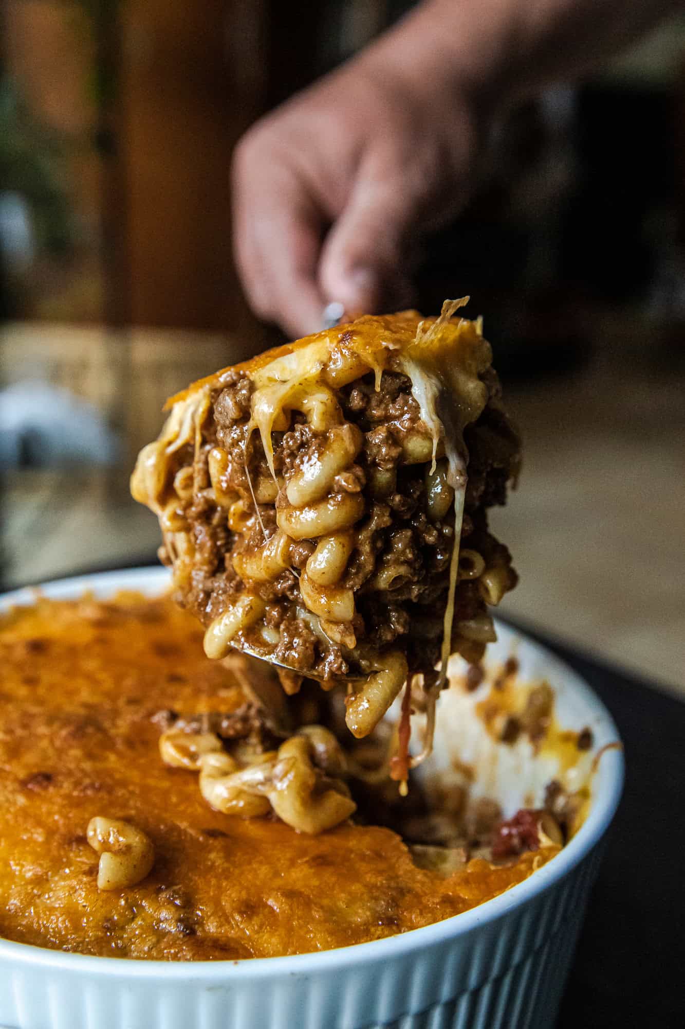 Close-up of a spoonful of chili mac with melted cheese and beef.