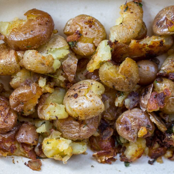 Blackstone smashed potatoes with rosemary on a griddle.