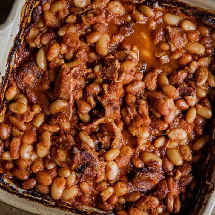 Traeger honey BBQ baked beans with bacon in a white baking dish.