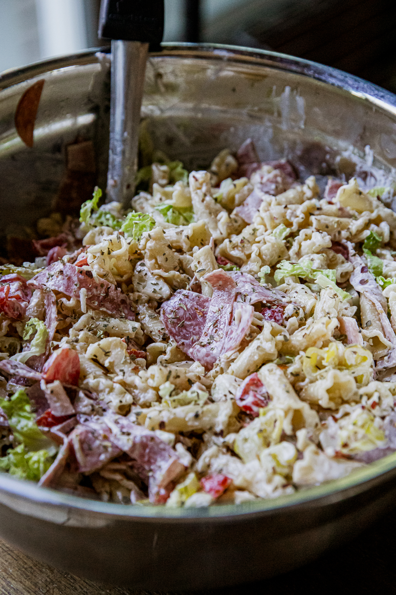 Close-up of Italian grinder pasta salad with meats and vegetables in a bowl.