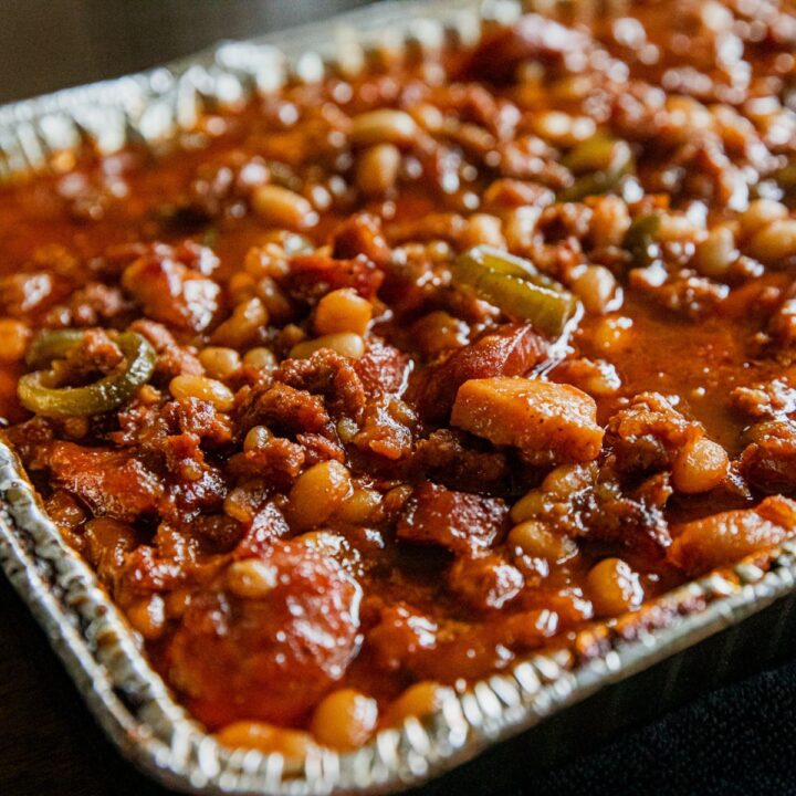 Spicy cowboy beans loaded with sausage, ground beef, and bacon.