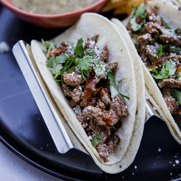 Blackstone tacos borrachos with steak and toppings.