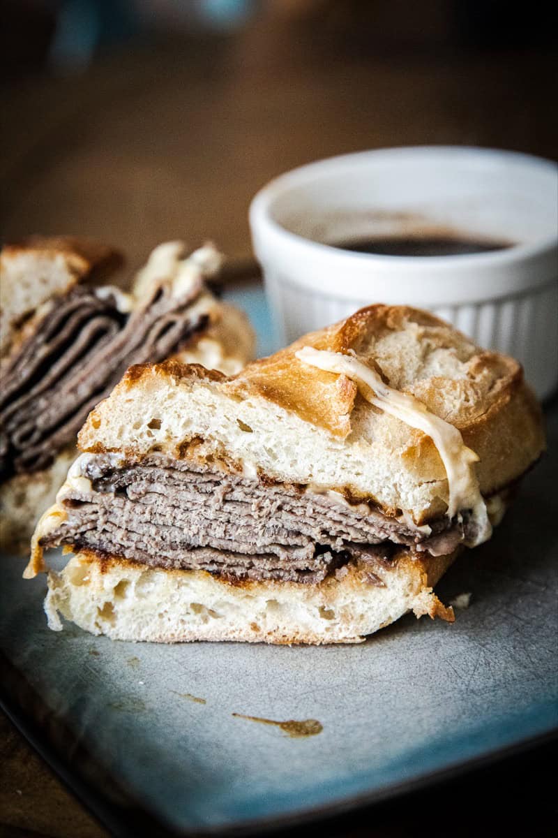 Close-up of a French dip sandwich with beef and au jus.