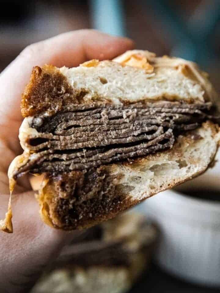 Close-up of a French dip sandwich with beef and bread.