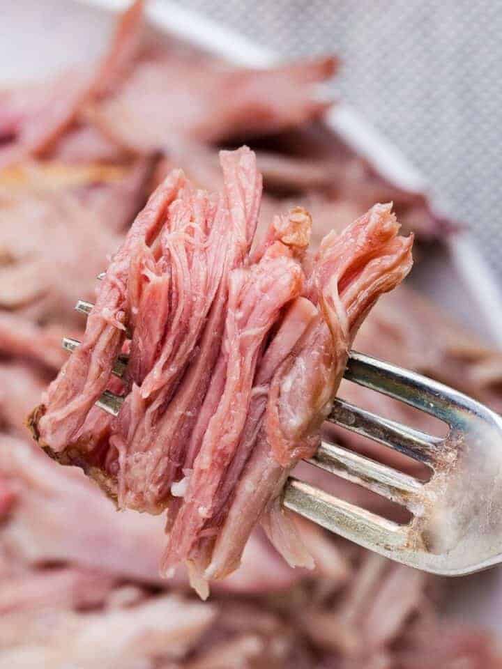 Tender, juicy double smoked picnic ham on a fork, ready to serve.