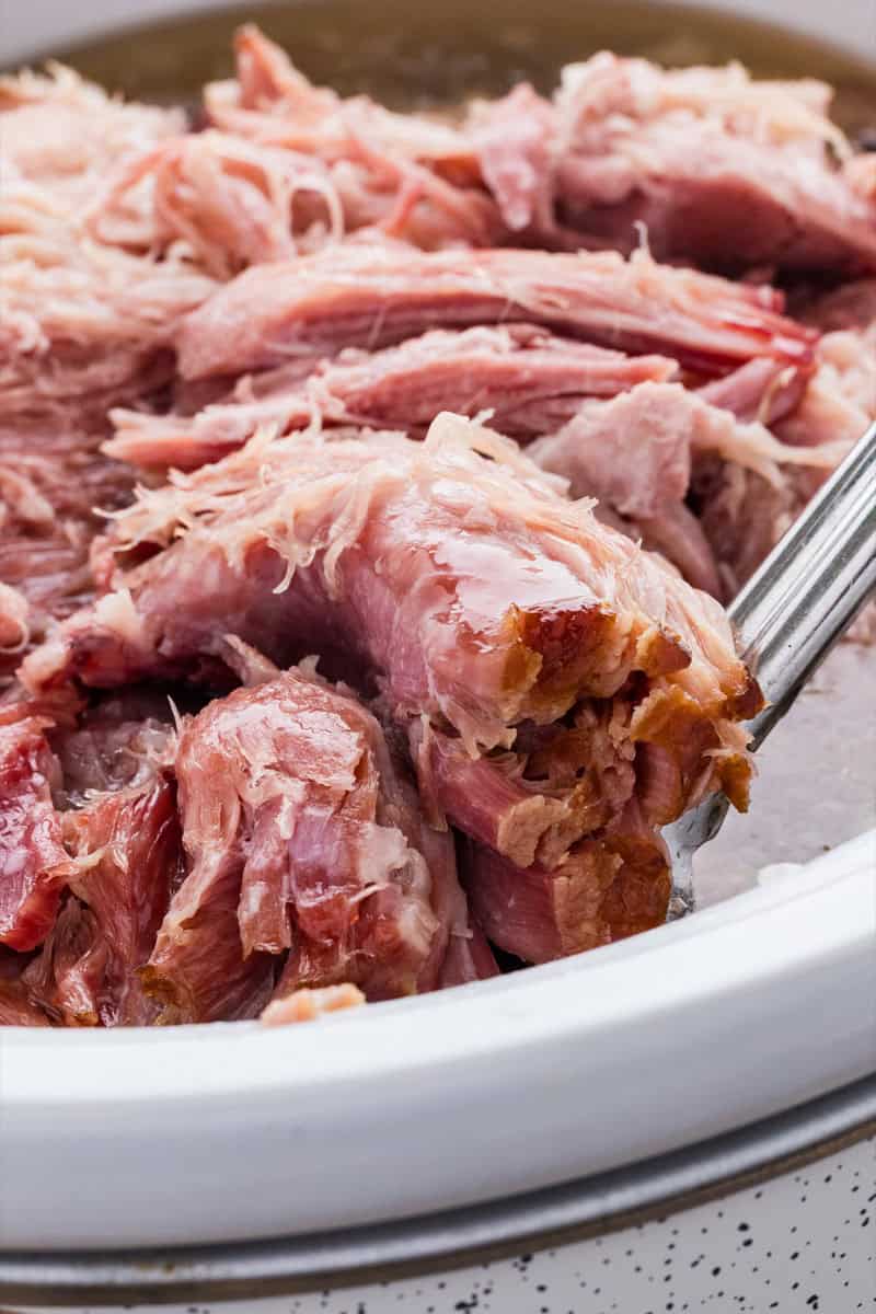 Close-up of tender, juicy double smoked picnic ham in a white dish.