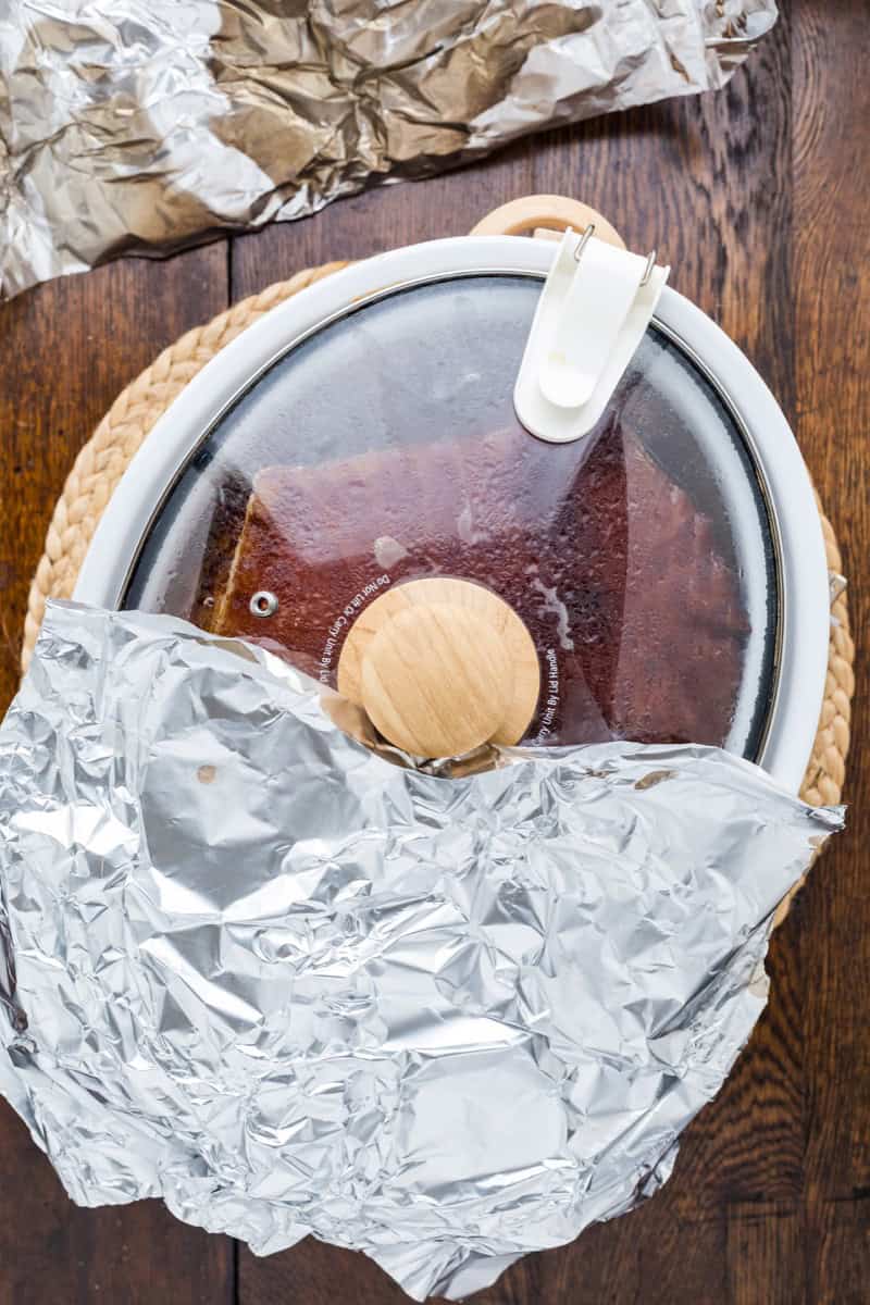 Double smoked picnic ham covered with glaze in a glass cloche.