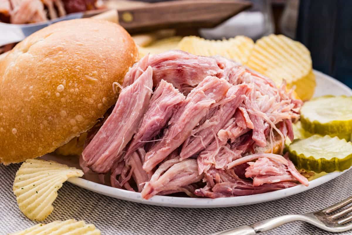 Juicy double smoked picnic ham served with pickles and bread.