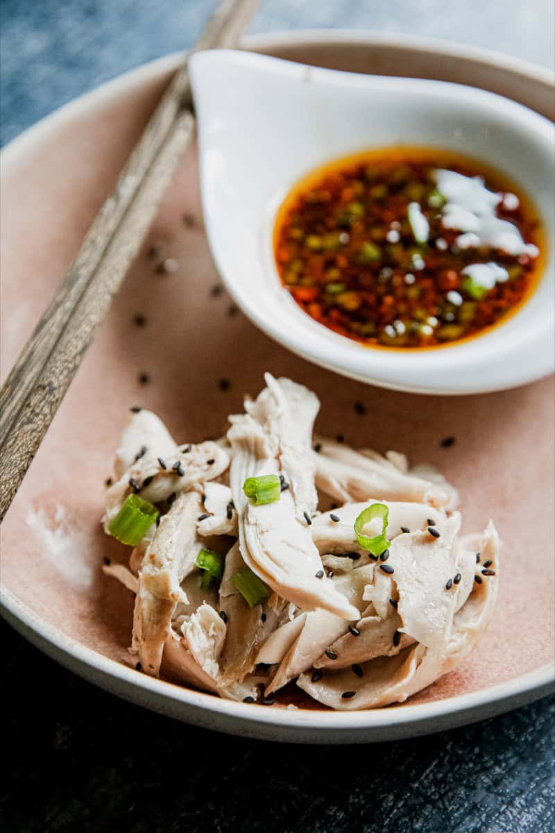 Steamed chicken slices with green onions and soy sauce-based dipping sauce.